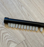 Black metal rod with white plastic clips on a wooden floor