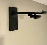 Black wall-mounted bracket on a beige wall