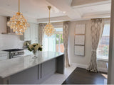 Curtains with damask pattern for 
Modern kitchen with marble island, chandelier, and large windows