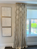 Decorative curtains with  functional roller blind .framed artwork on a wall in a room with a window.