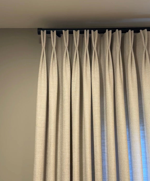 Beige curtains hanging against a plain wall
